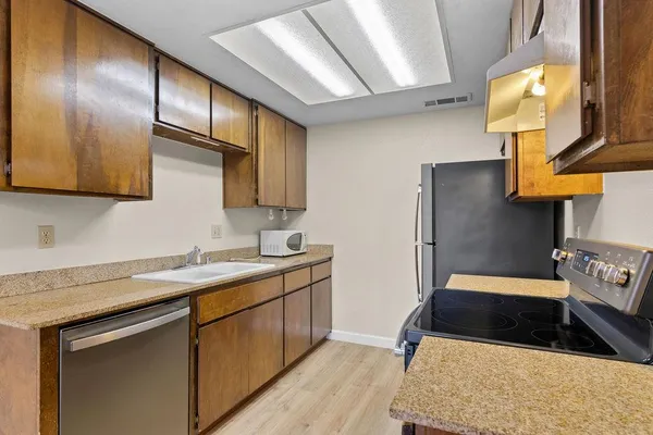 a kitchen with stainless steel appliances granite countertop a sink stove and refrigerator