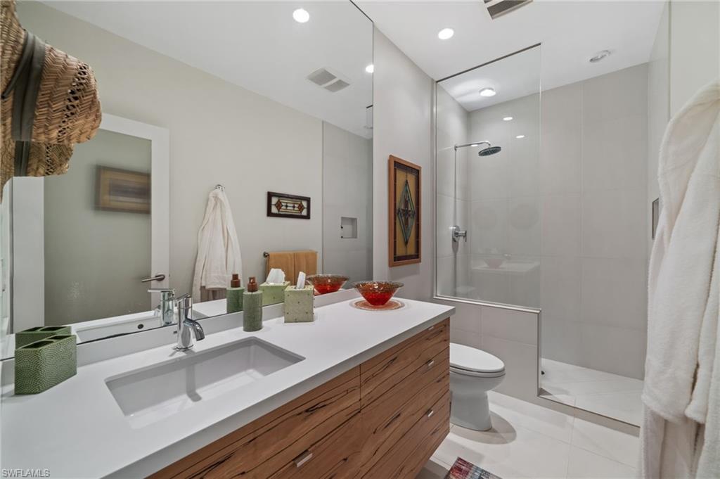 361 2nd Street South Naples, FL 34102 - Photo 18 of 31 a bathroom with a double vanity sink toilet and shower