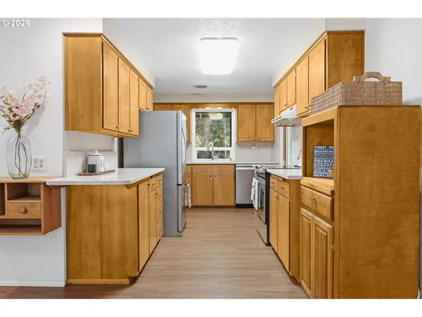 a kitchen with stainless steel appliances granite countertop a sink a stove cabinets and wooden floor