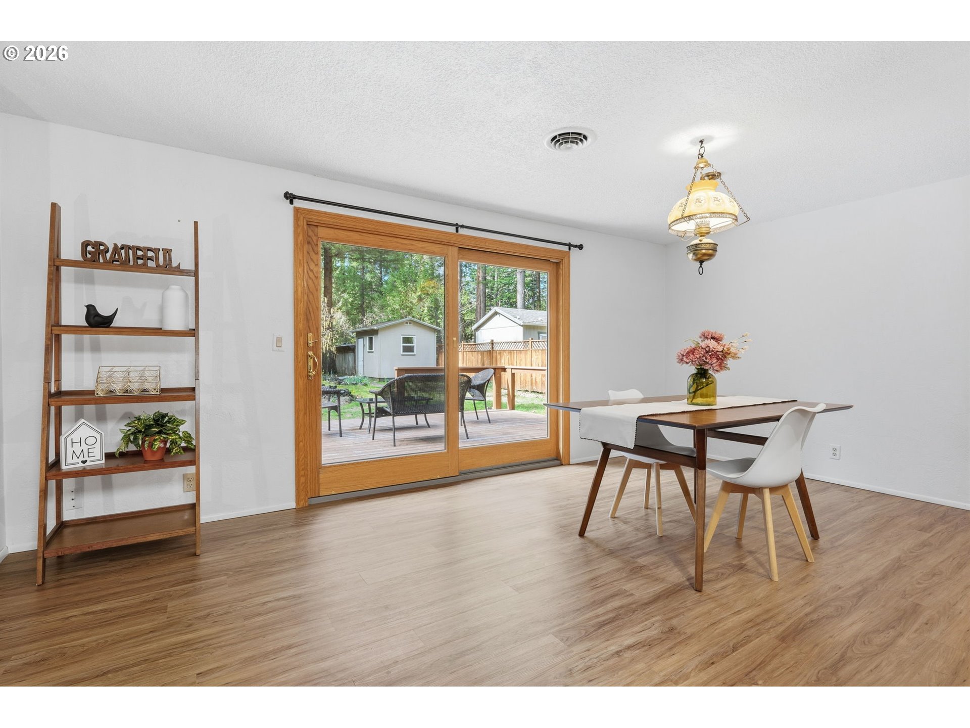 91638 Horse Creek Road Blue River, OR 97413 - Photo 9 of 47 a dining room with wooden floor a chandelier a wooden table and chairs