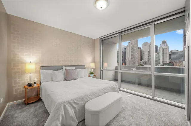 a bedroom with a large bed and a chandelier