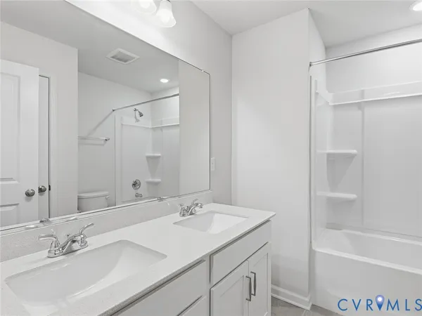 a bathroom with a sink double vanity granite tub shower and a mirror