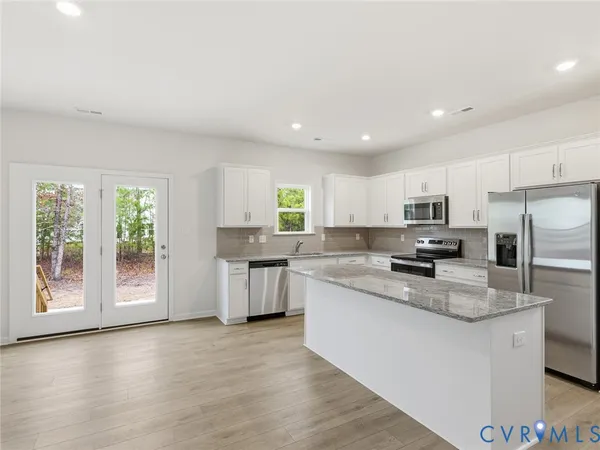 a kitchen with stainless steel appliances granite countertop a stove a sink and a refrigerator