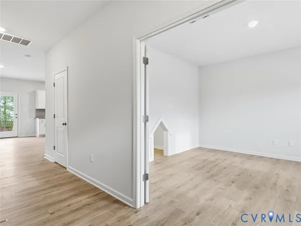 a view of a room with wooden floor and white walls