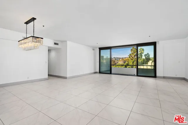 a large white kitchen with a large counter top stainless steel appliances and cabinets