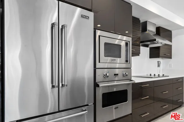 a large kitchen with a large counter top stainless steel appliances and cabinets