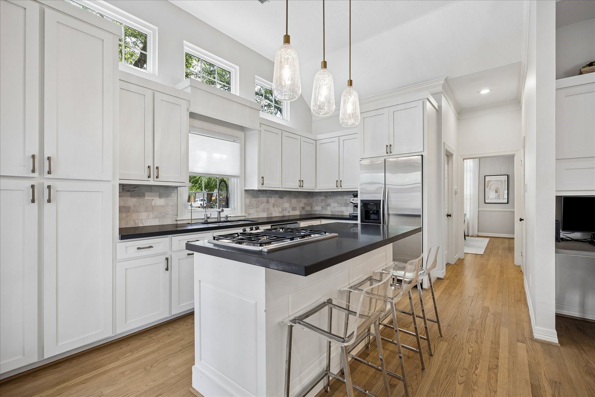 4131 Sunset Boulevard Houston, TX 77005 - Photo 15 of 38 a kitchen with stainless steel appliances a stove a sink dishwasher a refrigerator and white cabinets with wooden floor