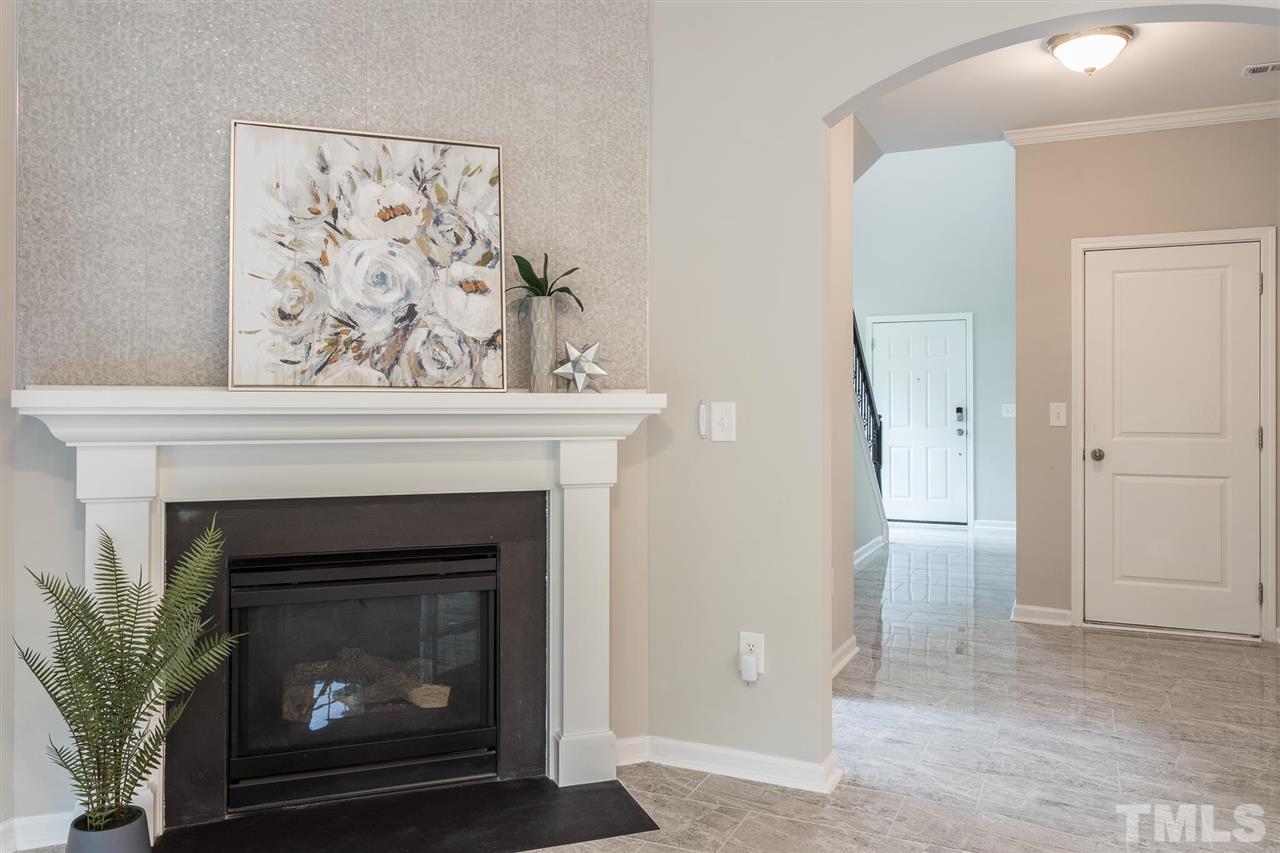 835 Davidson Point Road Cary, NC 27513 - Photo 5 of 30 a living room with a fireplace and a painting on the wall