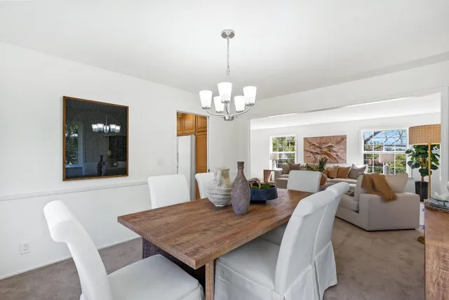 a view of a dining room with furniture a chandelier and wooden floor