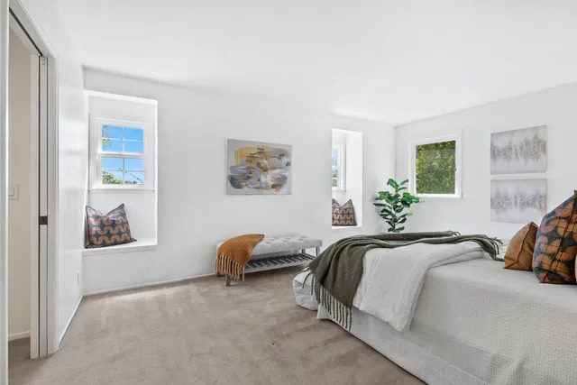 a bedroom with a bed and painting on the wall