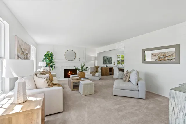 a living room with furniture a fireplace and a large mirror