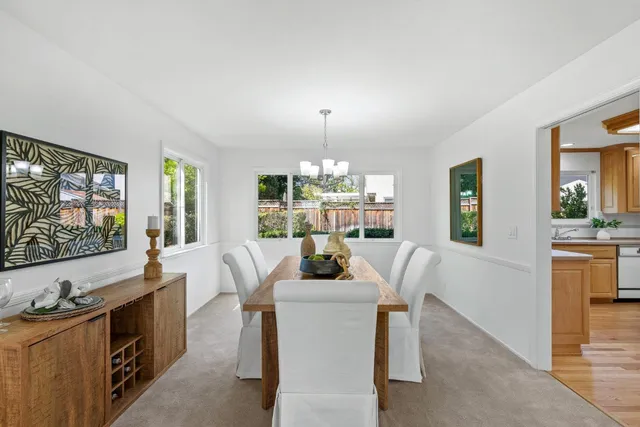 a dining room with furniture a chandelier and a flat screen tv