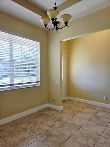 a view of a room with a chandelier fan and windows