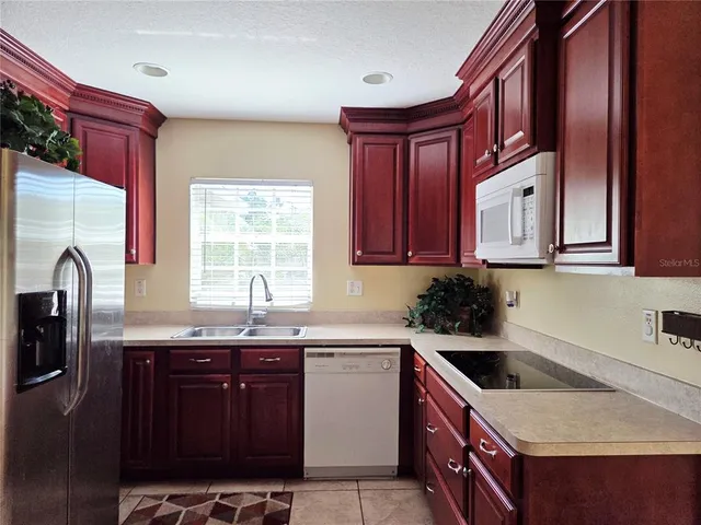 a kitchen with granite countertop a sink a stove and cabinets
