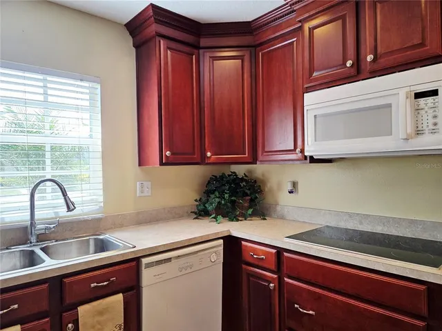 a kitchen with stainless steel appliances granite countertop a sink a microwave cabinets and wooden floor