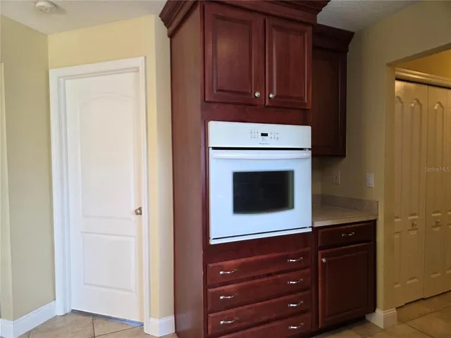 a room with wooden cabinets and a stove top oven