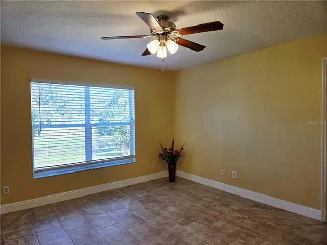a view of a livingroom with a chandelier fan and a window