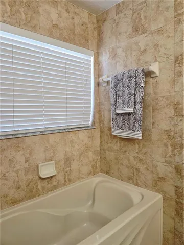 a bathroom with a white bath tub and a shower