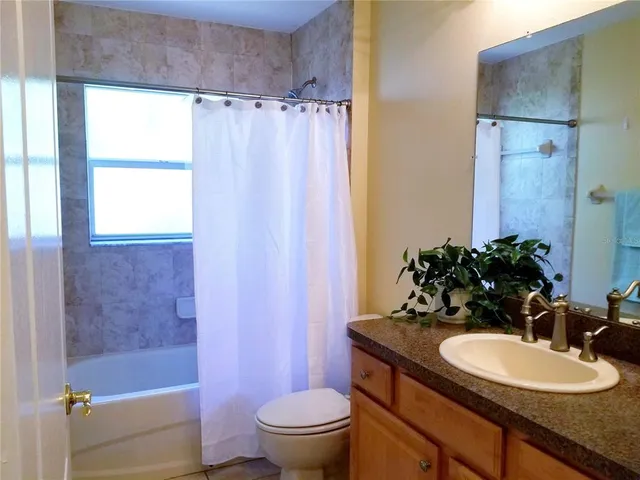 a bathroom with a sink a toilet a tub and shower