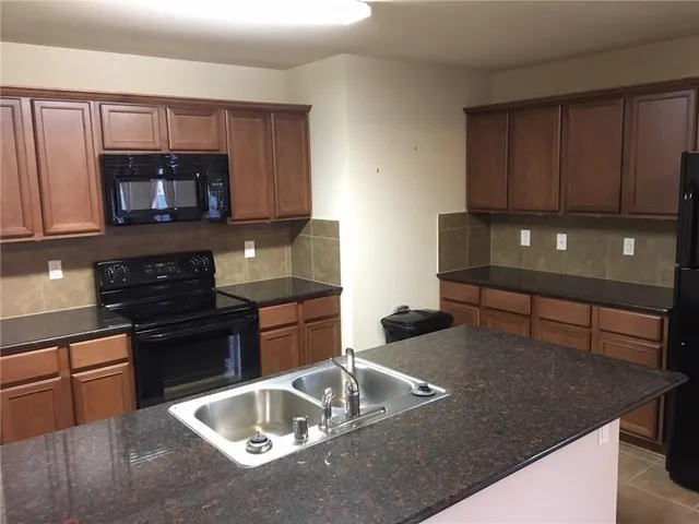 a kitchen with a sink and steel appliances