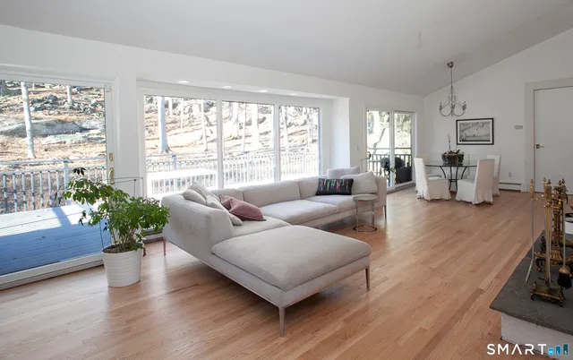 a living room with furniture large window and wooden floor