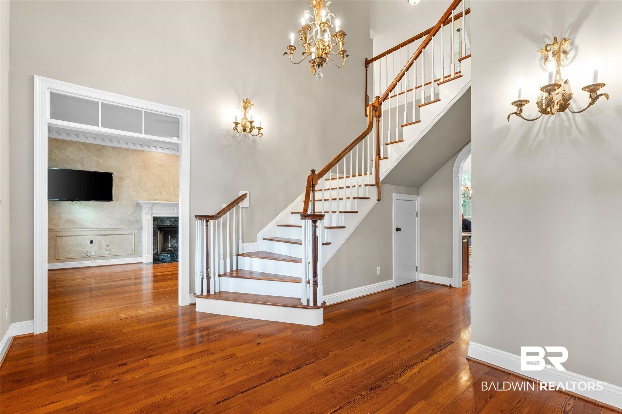 5231 Dawes Road Grand Bay, AL 36541 - Photo 3 of 49 Stairway with a high ceiling, hardwood / wood-style floors, a chandelier, and a premium fireplace
