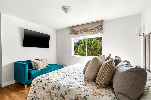 a bedroom with a bed a television and a window