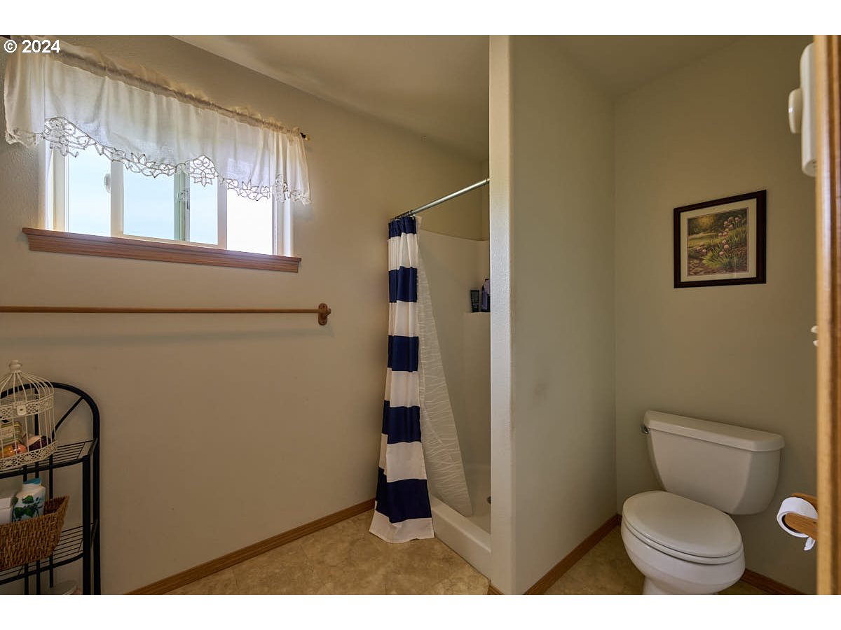 76012 Highway 82 Elgin, OR 97827 - Photo 20 of 41 a bathroom with a toilet sink a shower and a window