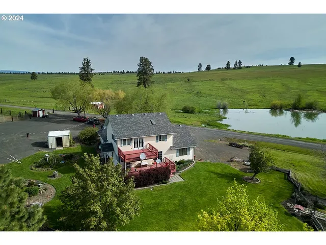 a aerial view of a house with a yard and lake view