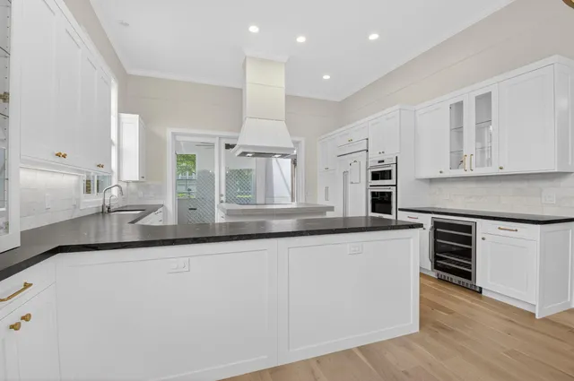 a kitchen with stainless steel appliances granite countertop a sink and white cabinets