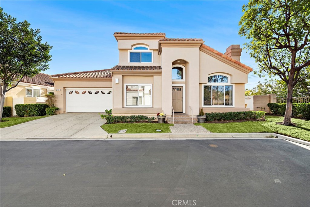 a front view of a house with a yard and a garage