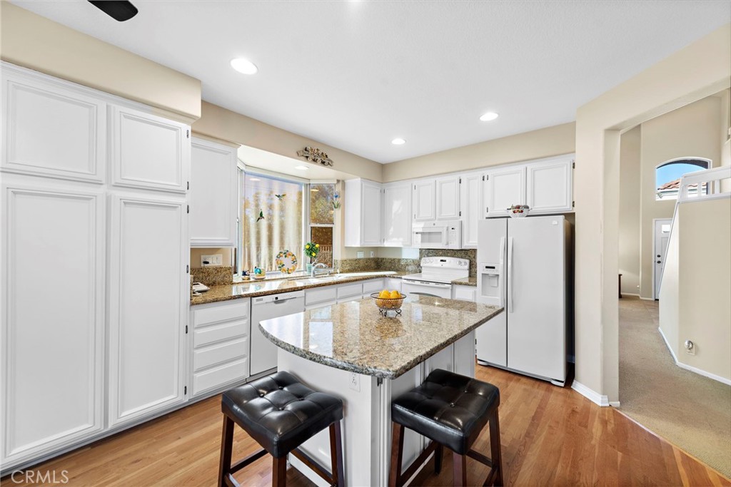 21191 Cancun Mission Viejo, CA 92692 - Photo 14 of 28 a kitchen with refrigerator cabinets and wooden floor