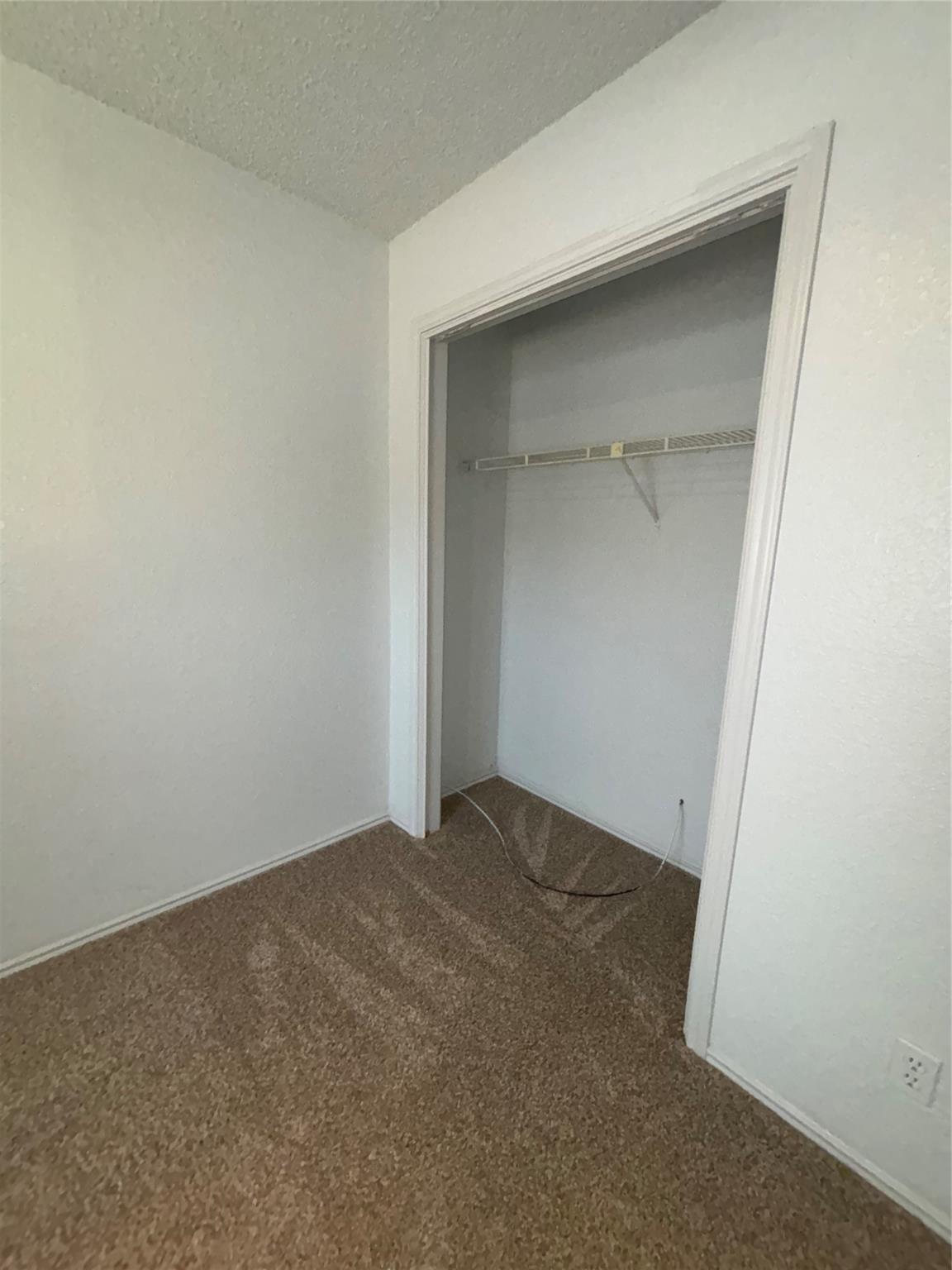 2033 Redwing Way Round Rock, TX 78664 - Photo 9 of 13 Recessed closet with wire shelving, neutral carpeting, and light-colored walls