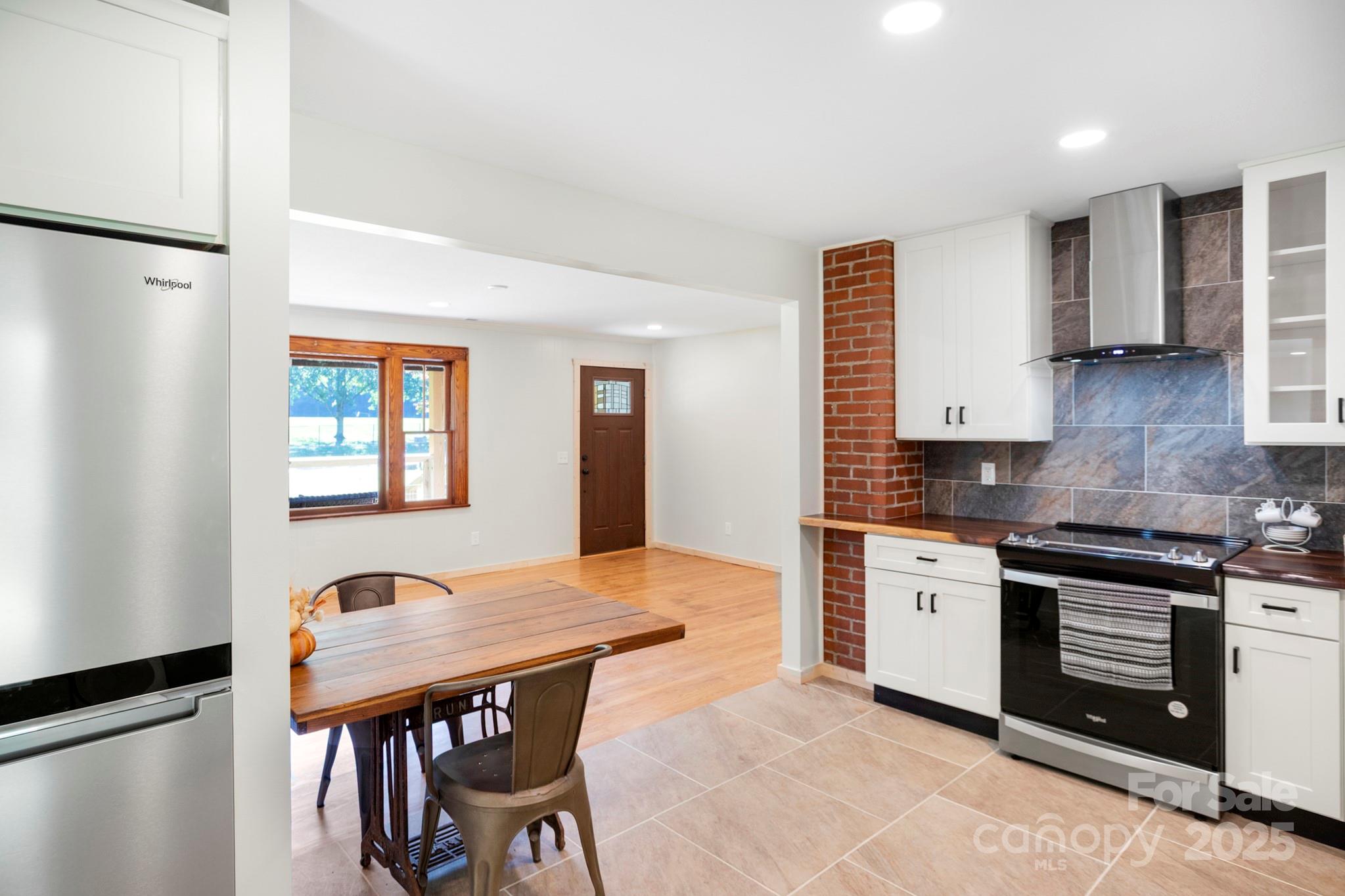 1808 Allens Creek Road Waynesville, NC 28786 - Photo 12 of 45 a kitchen with stainless steel appliances granite countertop a stove top oven a sink dishwasher and a refrigerator with wooden floor