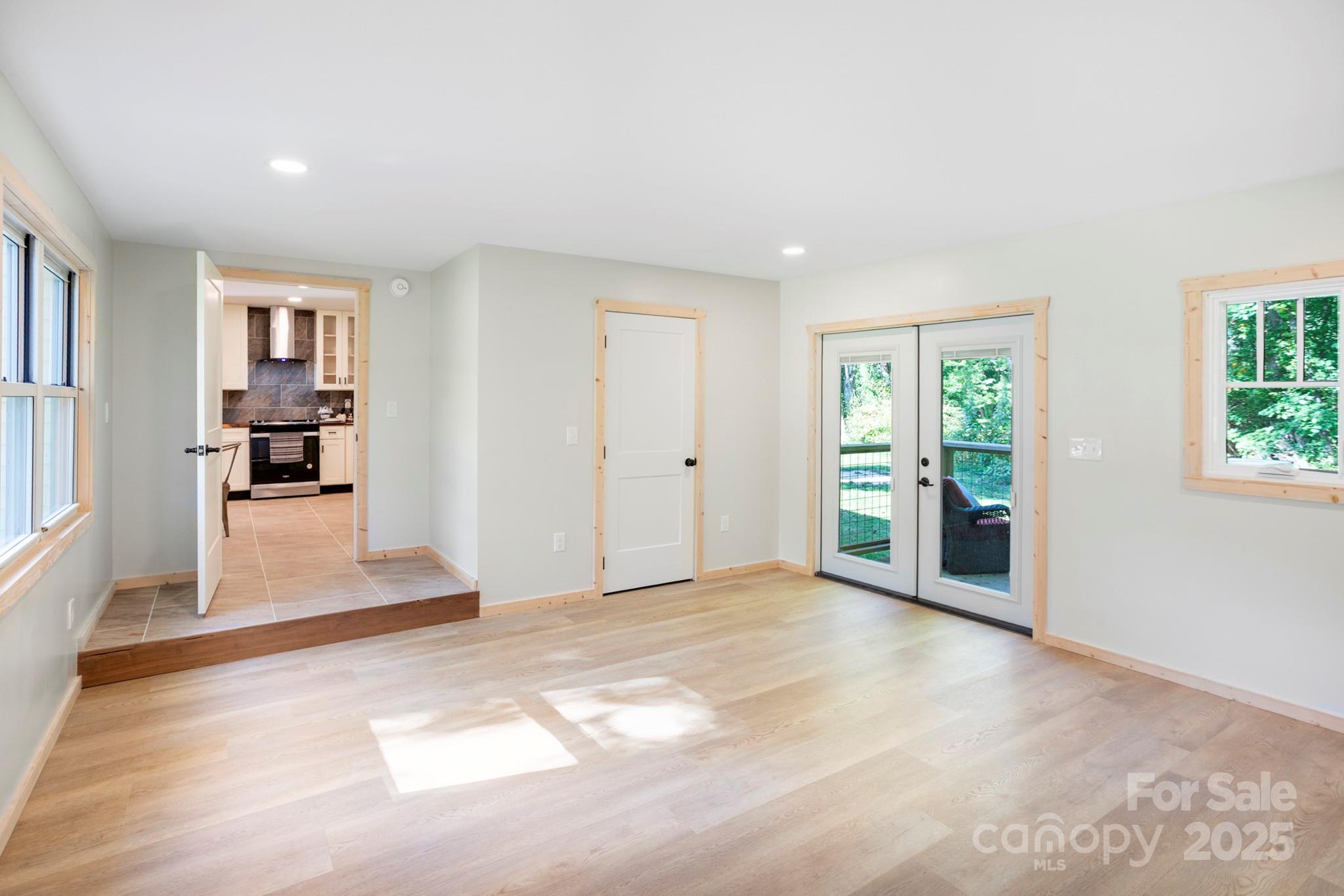 1808 Allens Creek Road Waynesville, NC 28786 - Photo 25 of 45 a view of a livingroom with wooden floor and a kitchen space