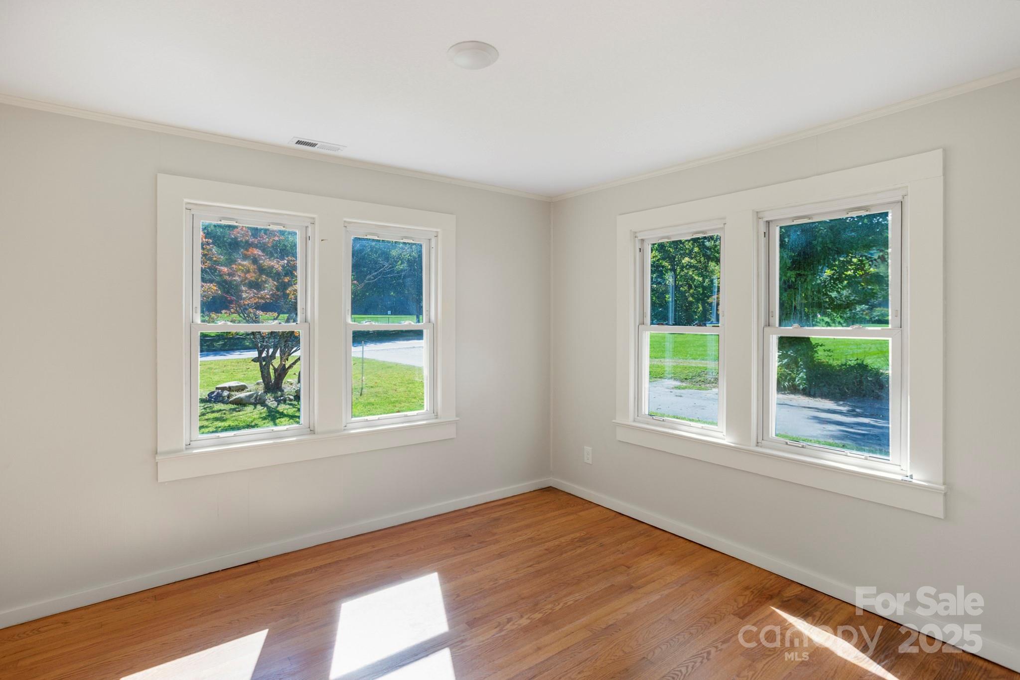 1808 Allens Creek Road Waynesville, NC 28786 - Photo 43 of 45 a view of an empty room with wooden floor and windows