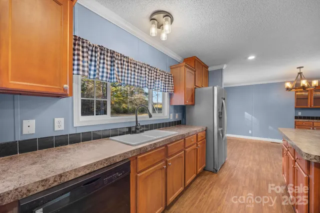 a kitchen with stainless steel appliances granite countertop a sink a stove and a wooden floor