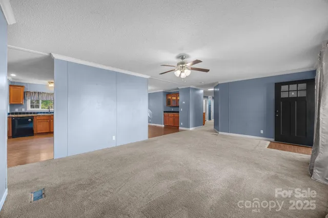 a view of an empty room with a kitchen