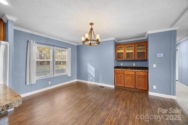 a view of empty room with wooden floor and entryway