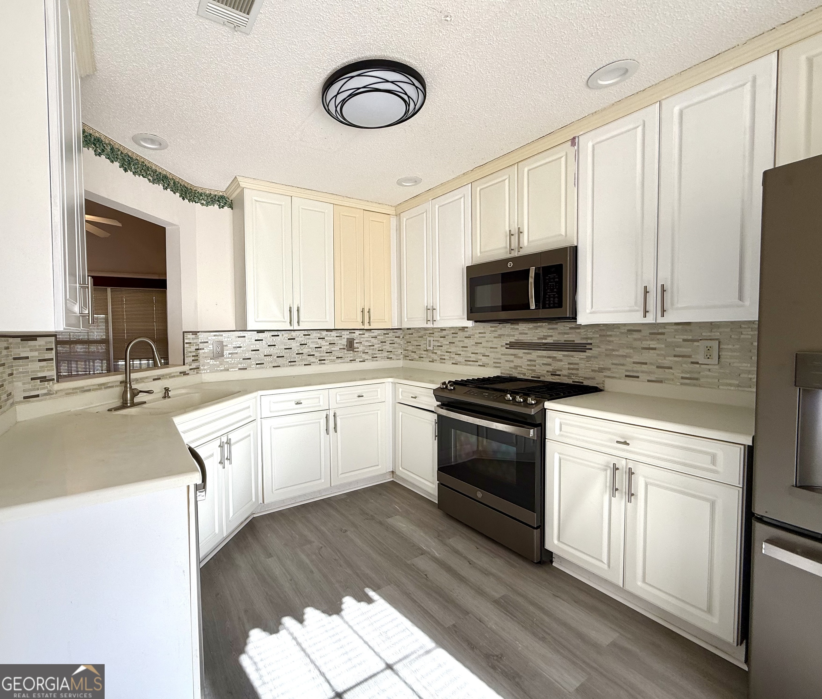 230 Mels Way Stockbridge, GA 30281 - Photo 3 of 40 a white kitchen with a stove a sink and a microwave
