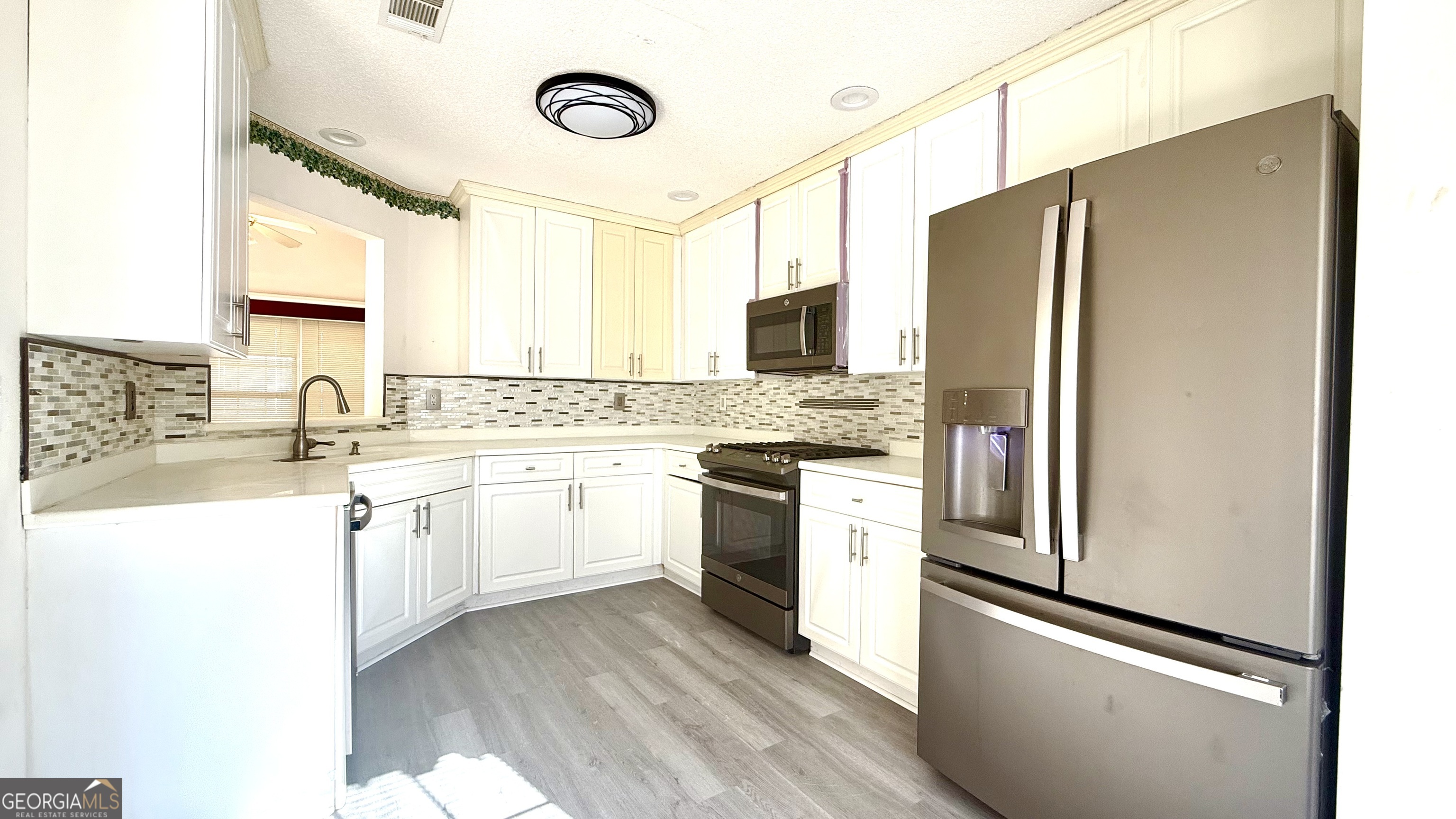 230 Mels Way Stockbridge, GA 30281 - Photo 4 of 40 a kitchen with white cabinets and stainless steel appliances