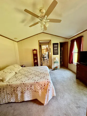 a bedroom with a bed and a flat tv screen on dresser