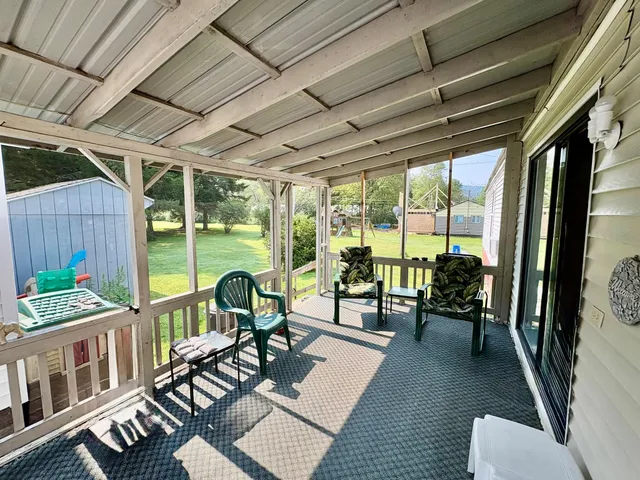 a living room with furniture floor to ceiling window and wooden floor