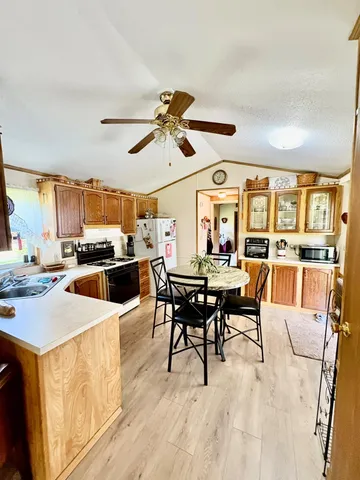 a kitchen with a table chairs refrigerator and cabinets
