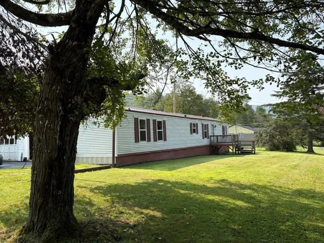 a backyard of a house with yard table and chairs
