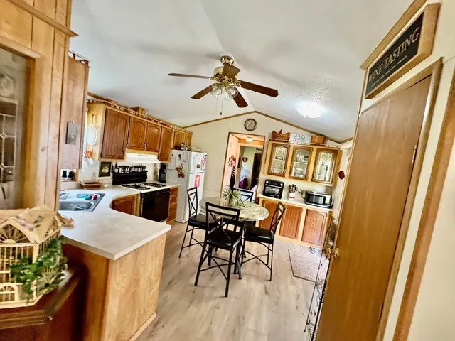 a view of a dining room with furniture and a kitchen view