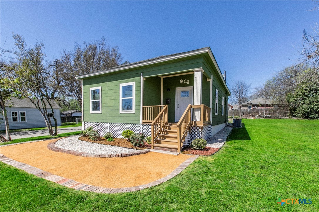 a view of a house with backyard and a tree