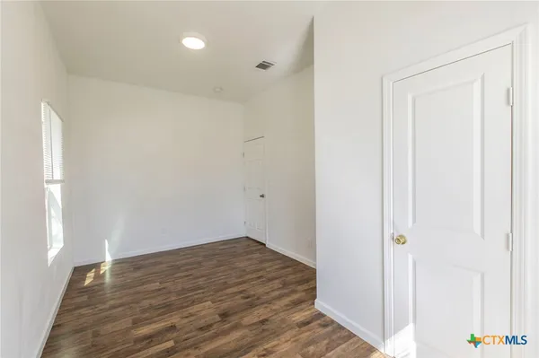 a view of a room with wooden floor and white doors