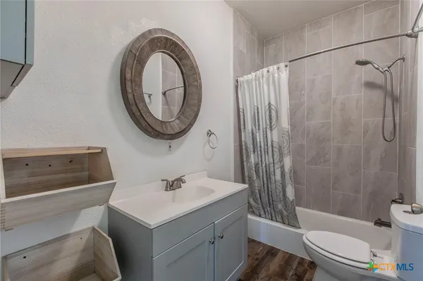a bathroom with a sink a toilet and shower