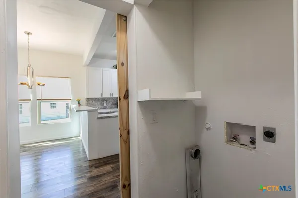 a view of a kitchen with refrigerator and wooden floor